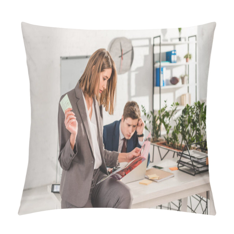 Personality  Selective Focus Of Woman Holding Sticky Note With Later Lettering And Reading Magazine With Coworker Sitting At Desk On Background, Procrastination Concept Pillow Covers