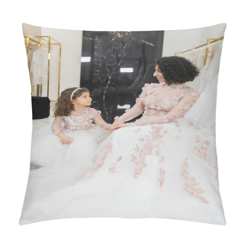 Personality  Happy And Brunette Middle Eastern Woman With Wavy Hair Looking At Cute Girl And Smiling Near White Wedding Dresses In Bridal Salon, Floral, Mother And Daughter, Happiness, Wedding Day, Shopping Pillow Covers