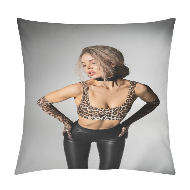 Personality  Sexuality And Confidence, Appealing Woman With Wavy Ash Blonde Hair Standing With Hands On Hips And Posing In Animal Print Crop Top, Long Gloves And Black Latex Pants On Grey Background Pillow Covers