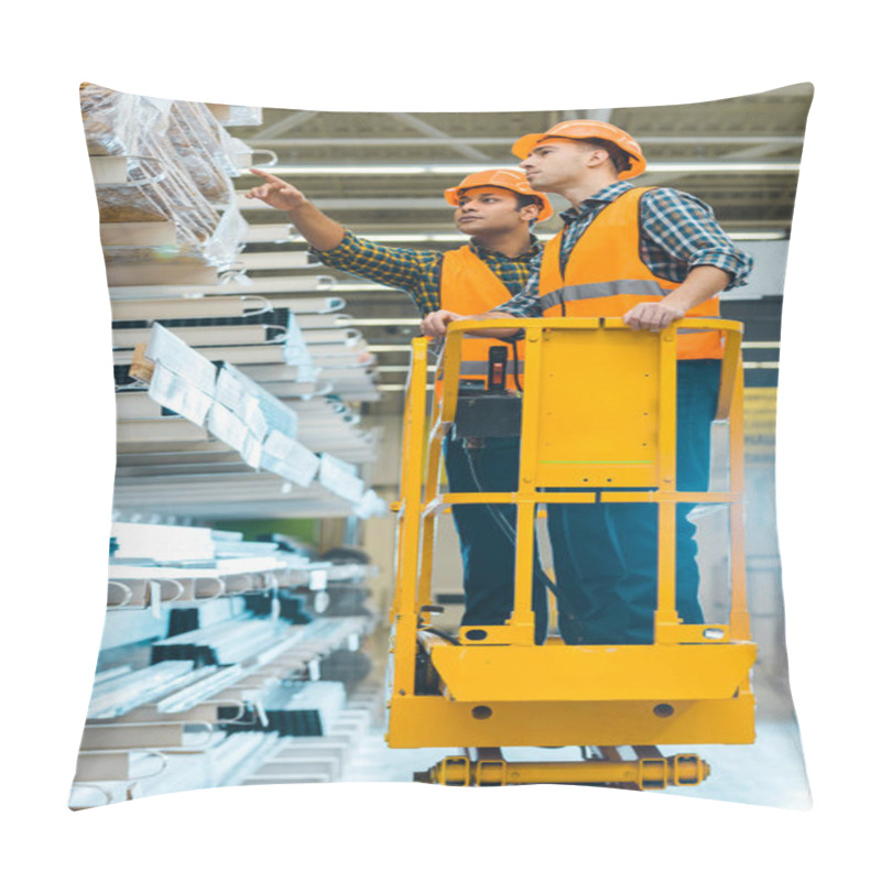 Personality  Serious Indian Worker Pointing With Finger At Construction Materials While Standing On Scissor Lift Near Colleague  Pillow Covers