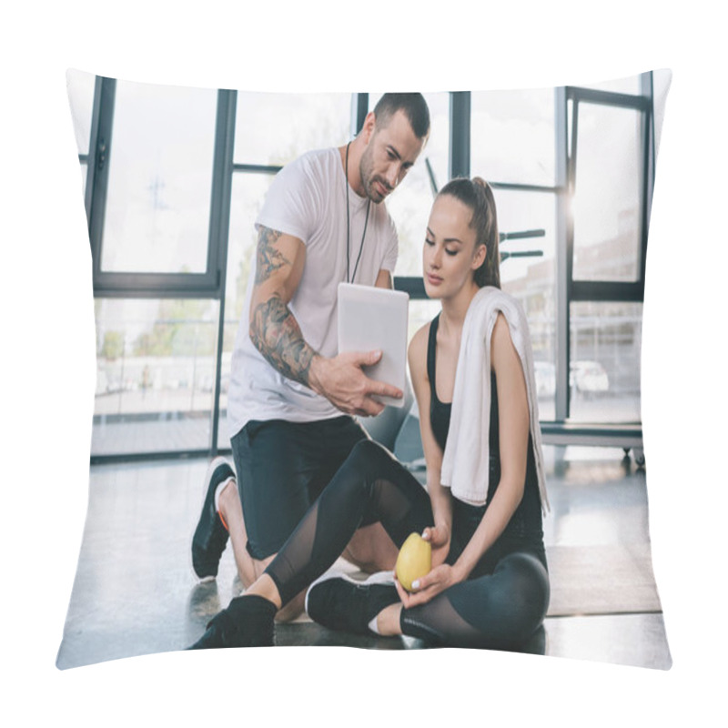 Personality  Male Personal Trainer Showing Digital Tablet To Sportswoman Sitting On Fitness Mat At Gym Pillow Covers