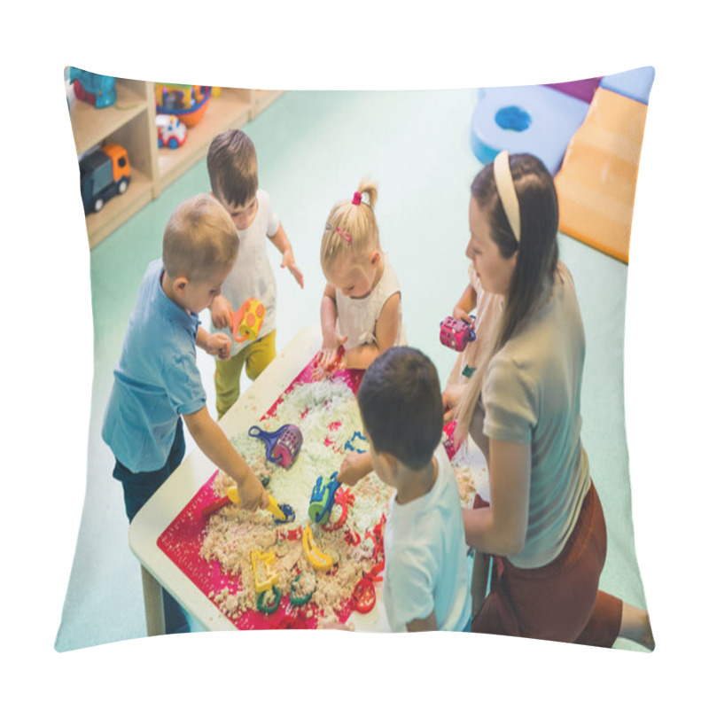 Personality  Calming Sensory Play With Moldable Kinetic Sand At Nursery School. Toddlers With Their Teacher Having Fun Around The Table Using Different Tools For Sculpting Sand Such As Colorful And Textured Pillow Covers