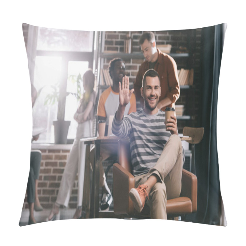 Personality  Cheerful Businessman Sitting In Armchair With Coffee To Go And Waving Hand At Camera Near Young Multicultural Colleagues Pillow Covers