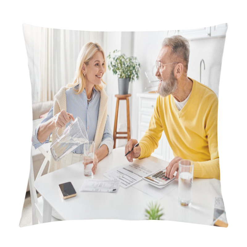 Personality  A Mature Man And Woman In Cozy Homewear Sitting At A Table, Focused On Using A Calculator For Financial Calculations. Pillow Covers