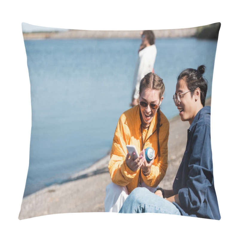 Personality  Cheerful Woman With Soda Can Showing Smartphone To Asian Friend Near River Pillow Covers