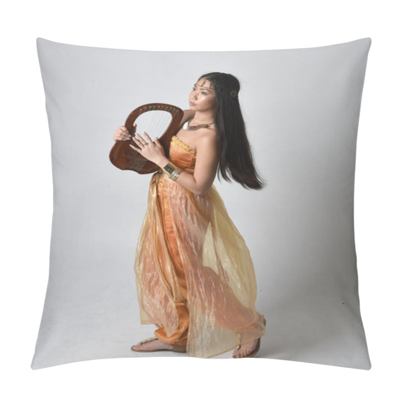 Personality  Full Length Portrait Of Pretty Young Asian Woman Wearing Golden Arabian Robes Like A Genie, Holding A Small Musical Harp, Isolated On Studio Background. Pillow Covers