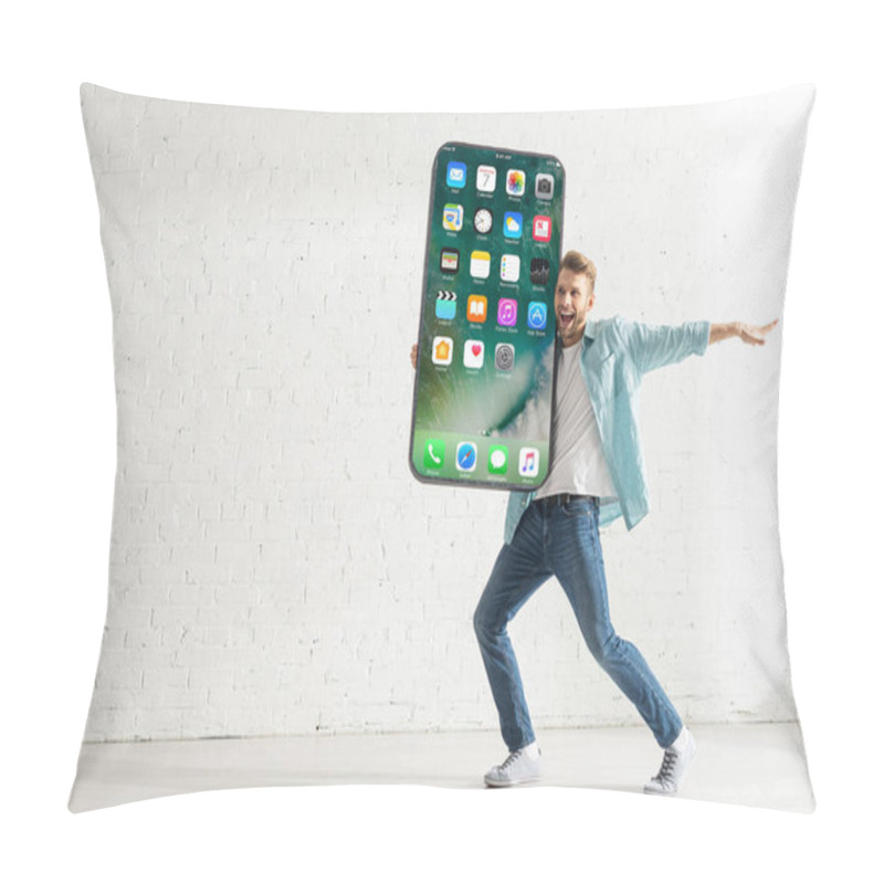 Personality  KYIV, UKRAINE - FEBRUARY 21, 2020: Happy Man Looking Away While Holding Model Of Smartphone With Iphone Screen At Home  Pillow Covers