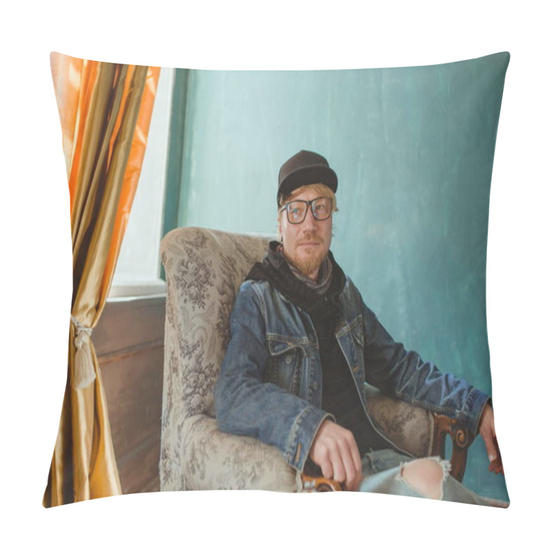 Personality  Portrait Of Modern Redhead Handsome Stylish Man In Black Hat And Jean Jacket And Sitting In The Armchair. Fashion And Style Concept Pillow Covers