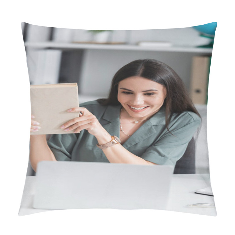 Personality  Smiling Teacher Holding Book During Online Lesson On Blurred Laptop In School  Pillow Covers