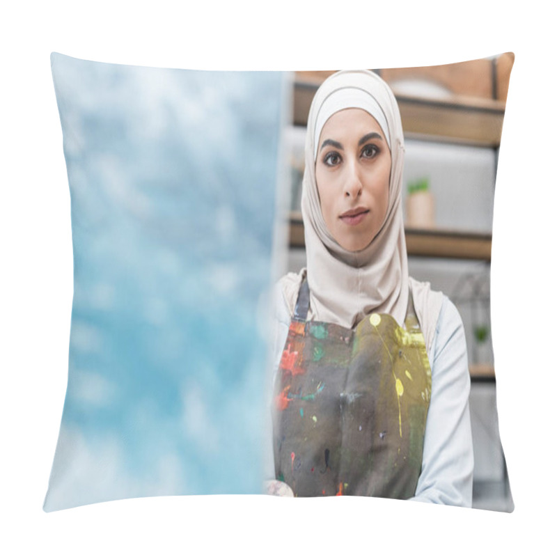 Personality  Young Arabian Woman In Hijab And Apron Looking At Camera Near Blurred Painting Pillow Covers