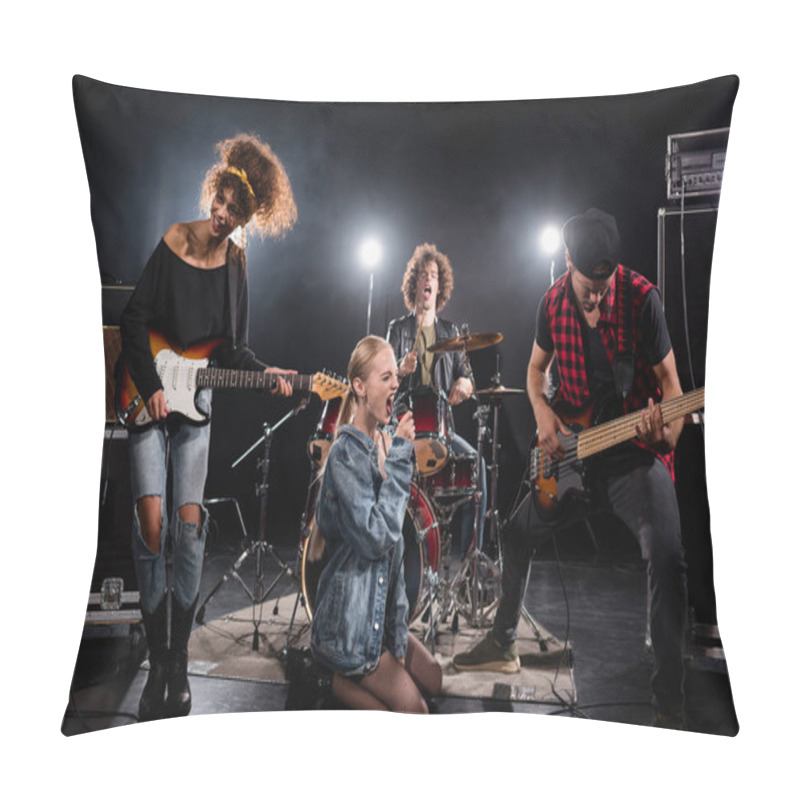 Personality  KYIV, UKRAINE - AUGUST 25, 2020: Blonde Woman With Microphone Screaming While Sitting On Knees During Rock Band Performance With Backlit On Black Pillow Covers