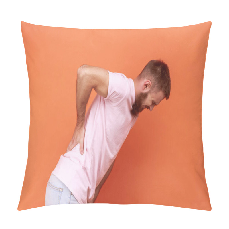 Personality  Side View Portrait Of Unhealthy Sick Bearded Man Standing And Holding His Painful Back, Suffering From Terrible Pain, Wearing Pink T-shirt. Indoor Studio Shot Isolated On Orange Background. Pillow Covers