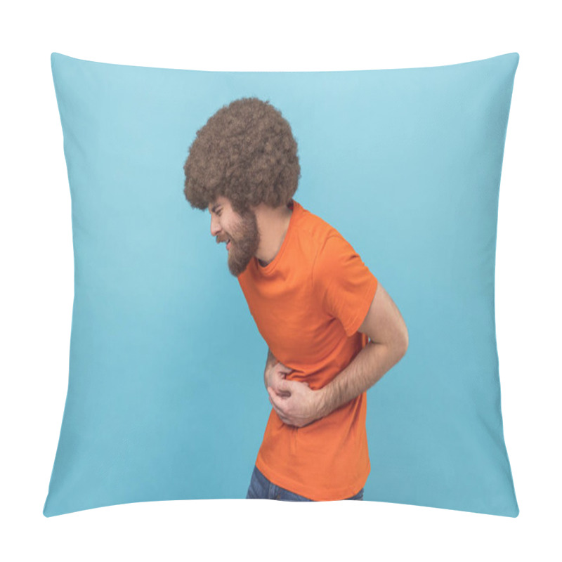 Personality  Stomach Pain. Side View Of Sick Sad Unhealthy Man With Afro Hairstyle Wearing Orange T-shirt Standing And Holding His Painful Belly. Indoor Studio Shot Isolated On Blue Background. Pillow Covers