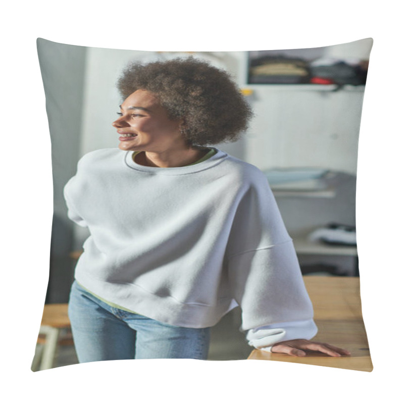 Personality  Portrait Of Cheerful Young African American Craftswoman In Sweatshirt And Jeans Looking Away While Standing Near Working Table In Blurred Print Studio, Enthusiastic Business Owner Working In Workshop Pillow Covers