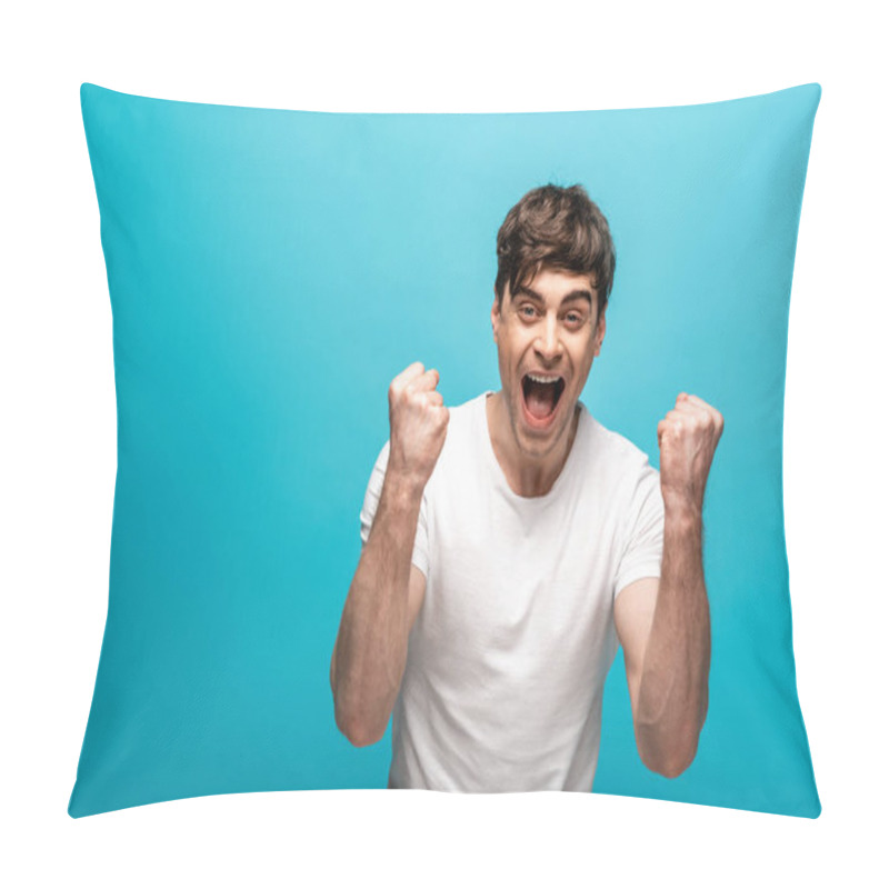 Personality  Happy Young Man Showing Winner Gesture While Looking At Camera On Blue Background Pillow Covers