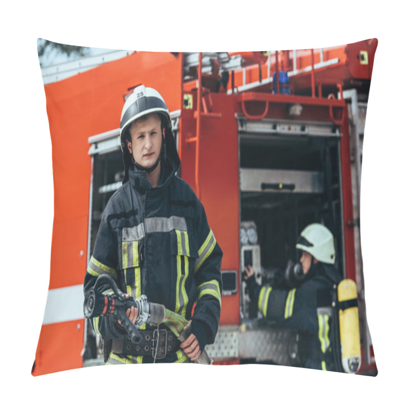 Personality  Male Firefighter In Uniform Holding Water Hose While Colleague Checking Equipment In Truck On Street Pillow Covers