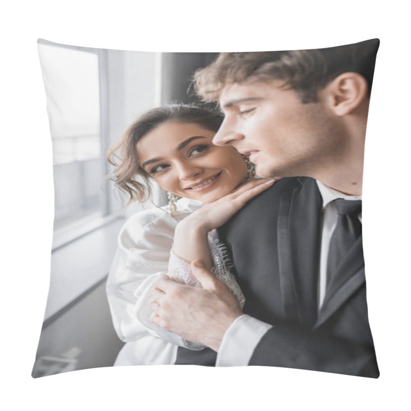 Personality  Happy Bride In Jewelry And White Silk Robe Leaning On Shoulder Of Blurred Groom In Classic Black Suit While Standing Together In Modern Hotel Room During Honeymoon, Newlyweds  Pillow Covers