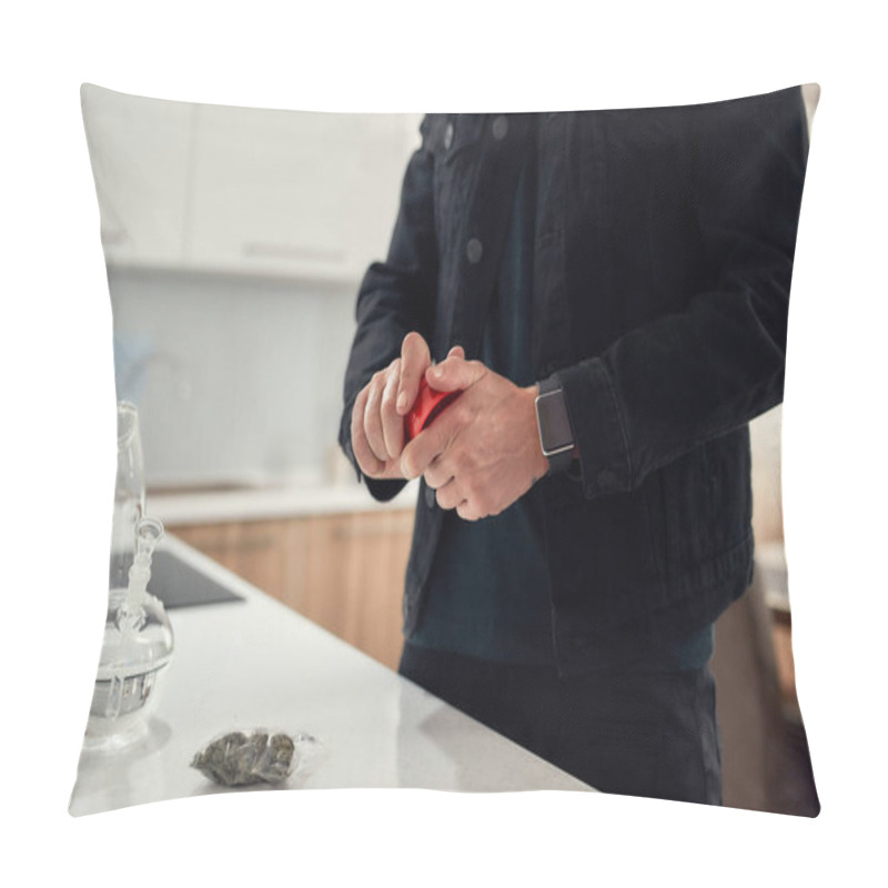 Personality  Cropped Shot Of Man Using Red Marijuana Grinder, While Standing In The Kitchen. Glass Water Pipe Or Bong, Cannabis Buds In A Plastic Bag On The Table Pillow Covers