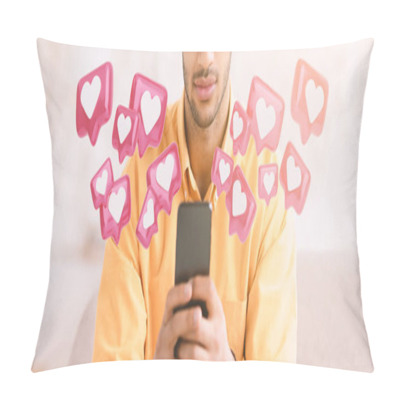 Personality  A Man Sits On A Couch, Holding A Smartphone In His Hands, Looking Down At The Screen. A Number Of Pink Heart Icons, Reminiscent Of Social Media Notifications, Float Around Him. Pillow Covers