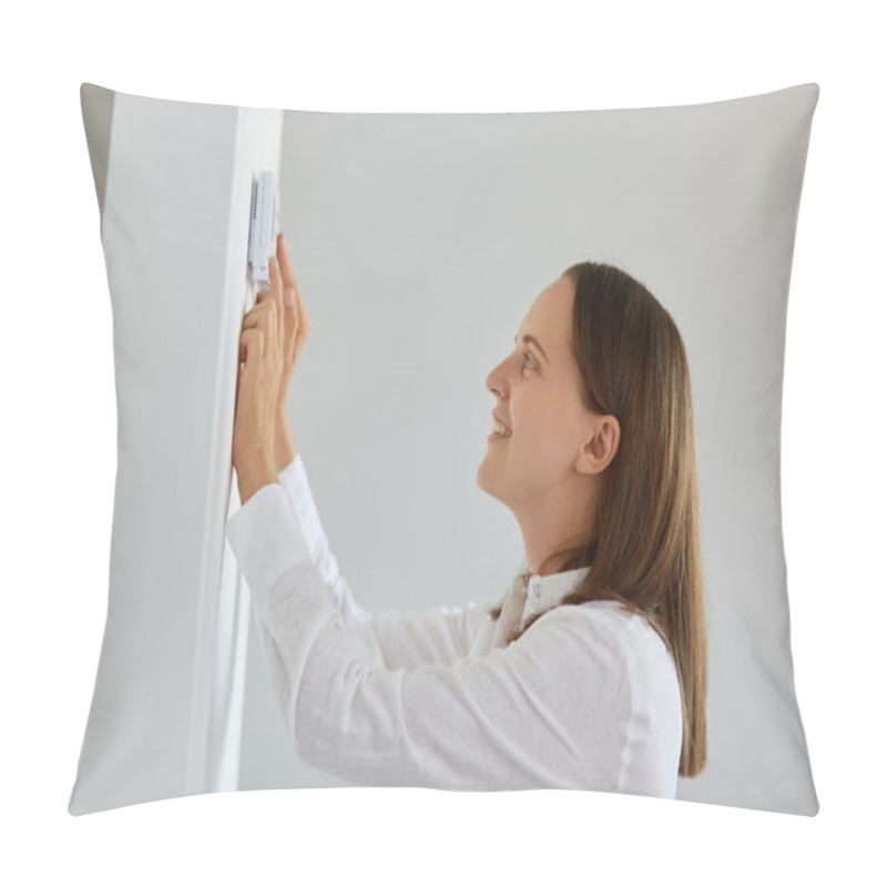 Personality  Side View Portrait Of Smiling Dark Haired Female Wearing White Shirt Regulating Heating Temperature With Thermostat On The White Wall In Light Room, Smart Home. Pillow Covers