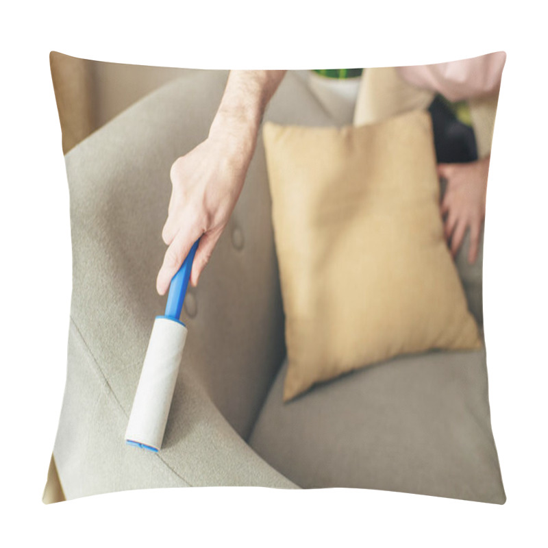 Personality  A Man In Cozy Homewear Meticulously Cleans A Couch Using A Blue Sticky Roller. Pillow Covers