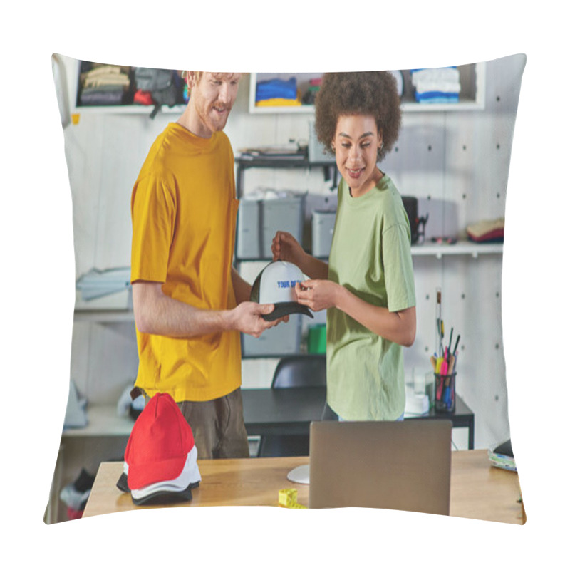 Personality  Smiling Young Multiethnic Designers Working With Printing Layer And Snapback While Looking At Laptop Near Cloth Samples In Print Studio At Background, Sustainable Business Model Concept Pillow Covers