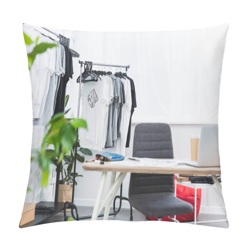 Personality  Selective Focus Of T-shirts On Hangers And Working Table With Laptop In Clothing Design Studio Pillow Covers