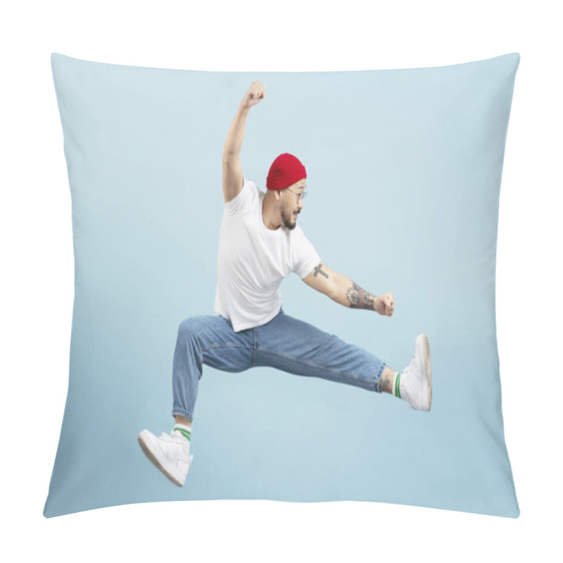 Personality  Handsome Asian Man, Fighter With Stylish Tattoo, Training Isolated On Blue Background. Korean Dancer Wearing Red Hat, Shoes, White T Shirt, Jumping High Looking Away. Sport, Advertisement Concept Pillow Covers