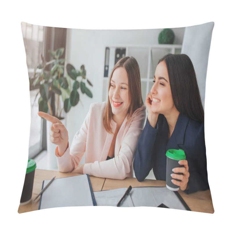 Personality  Two Young Women Sit Together At Table In Mooeting Room. One Model Point With Finger And Laugh. Her Friend Hold Cup Of Coffee And Look To Left. She Laughing Too. Pillow Covers