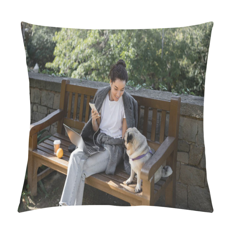 Personality  Smiling Freelancer In Earphones Holding Smartphone And Looking At Pug Dog While Sitting Near Laptop, Coffee To Go And Orange On Wooden Bench And Spending Time In Park In Barcelona, Spain  Pillow Covers