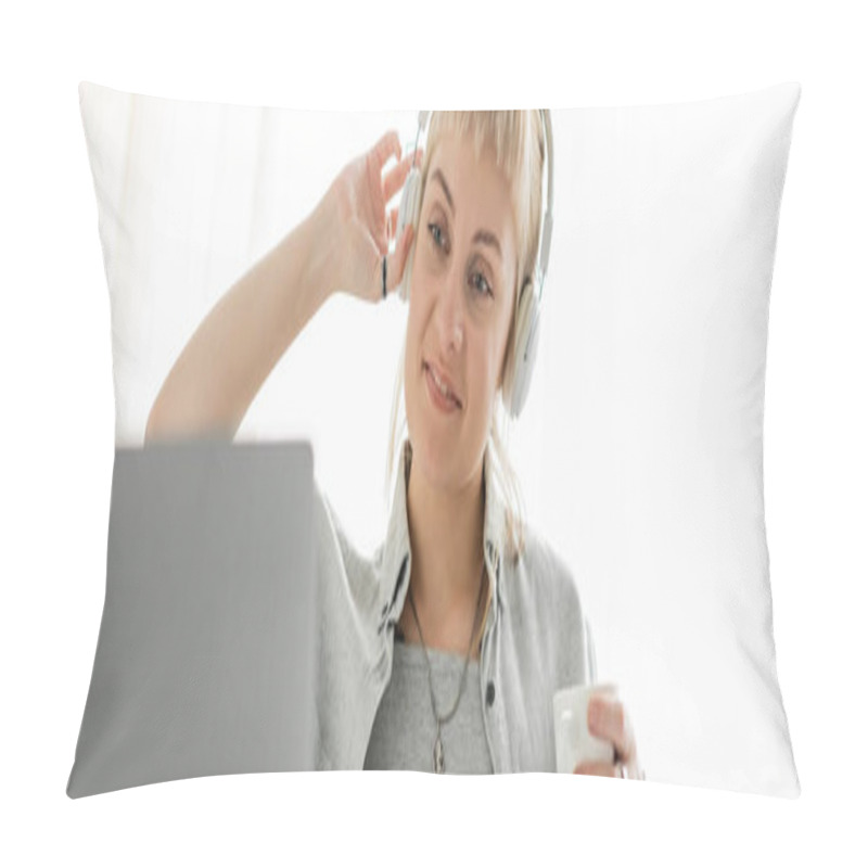 Personality  Smiling Young Woman With Bangs Sitting In Wireless Headphones And Holding Cup Of Coffee While Looking At Blurred Laptop At Home, Freelance, Work From Home, Banner  Pillow Covers