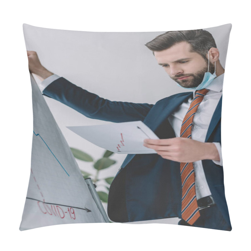 Personality  Thoughtful Businessman Looking At Document While Standing Near Flipchart With Covid-19 Inscription And Graphs Showing Decrease Pillow Covers