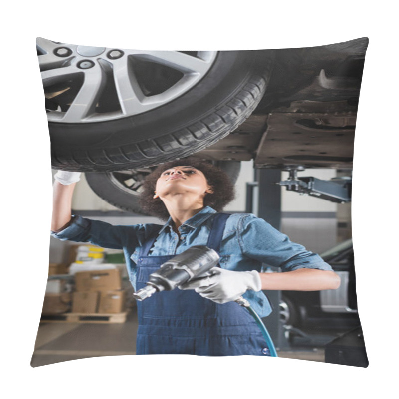 Personality  Young African American Mechanic In Overalls Repairing Wheel On Lifted Car With Electric Screwdriver In Garage Pillow Covers