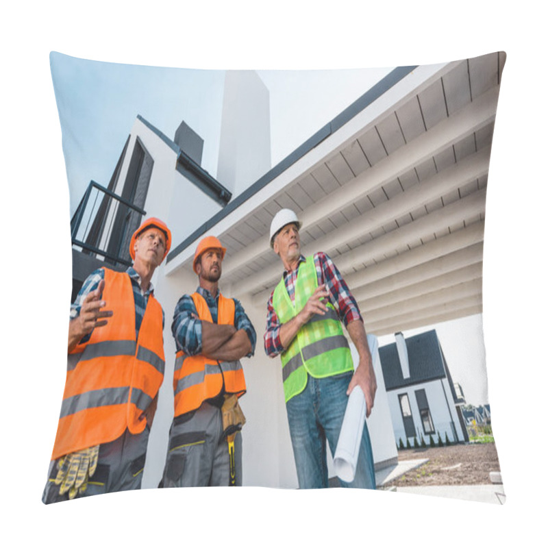 Personality  Low Angle View Of Constructors In Helmets Standing Near Coworker With Blueprint  Pillow Covers