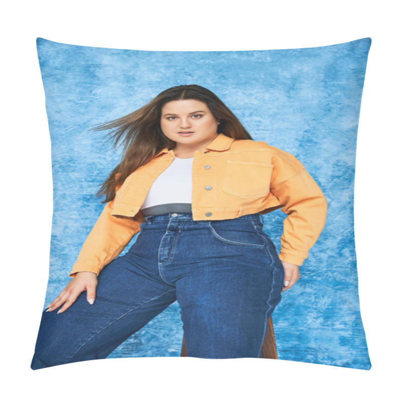 Personality  Body Positive And Brunette Plus Size Woman With Long Hair And Natural Makeup Wearing Crop Top, Orange Jacket And Denim Jeans While Posing And Looking At Camera On Mottled Blue Background Pillow Covers