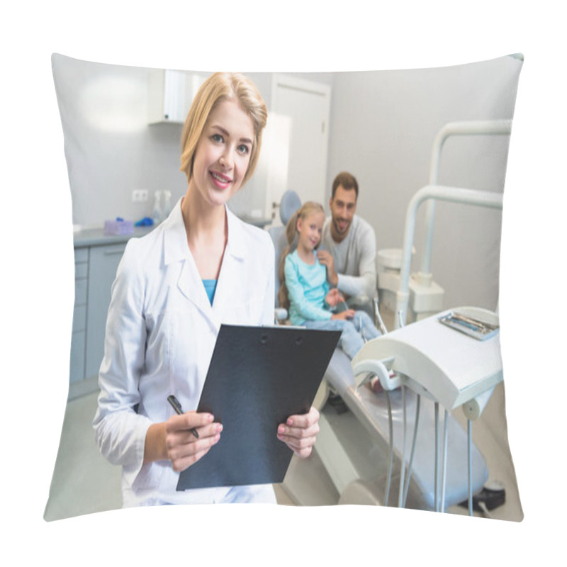 Personality  Beautiful Female Dentist With Clipboard Looking At Camera While Little Child And Her Father Sitting On Background Pillow Covers