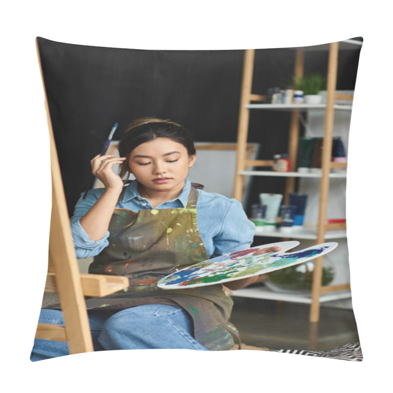 Personality  A Young Asian Woman Sits In Her Art Studio, Holding A Paintbrush And Palette, Focused On Her Artwork. Pillow Covers