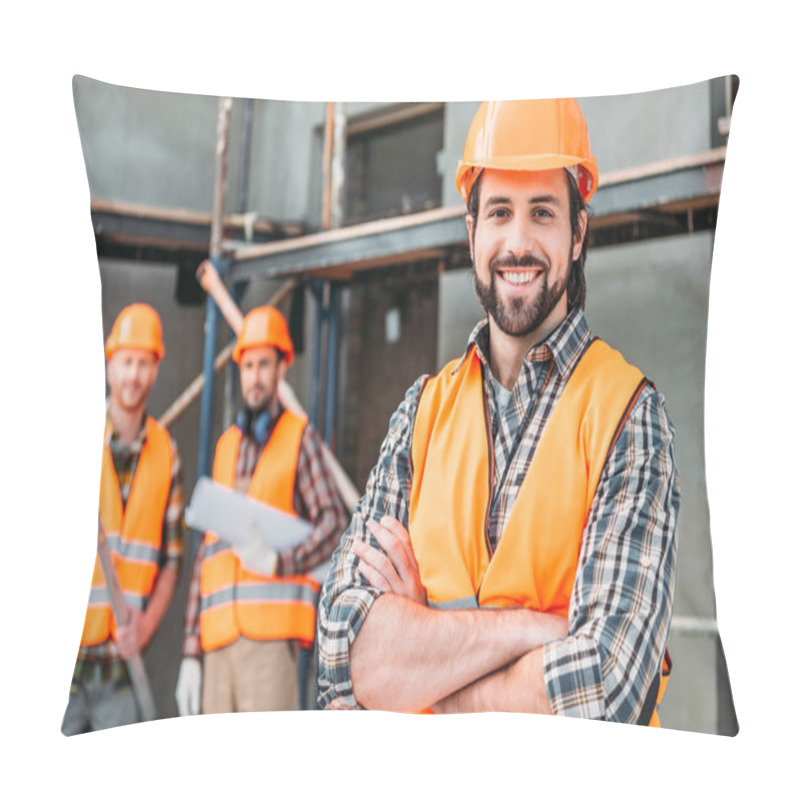 Personality  Handsome Smiling Builder Standing At Construction Site With Crossed Arms While His Colleagues Standing Blurred On Background Pillow Covers