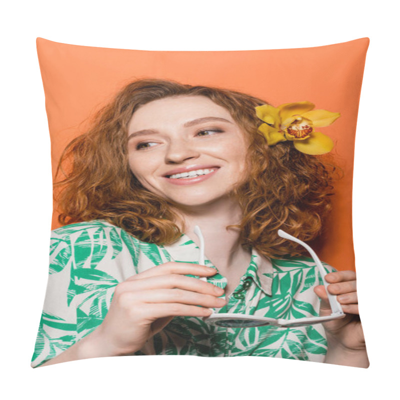 Personality  Positive Young Redhead Woman With Orchid Flower In Hair Wearing Blouse With Floral Pattern And Holding Sunglasses On Orange Background, Summer Casual And Trendy Concept, Youth Culture Pillow Covers