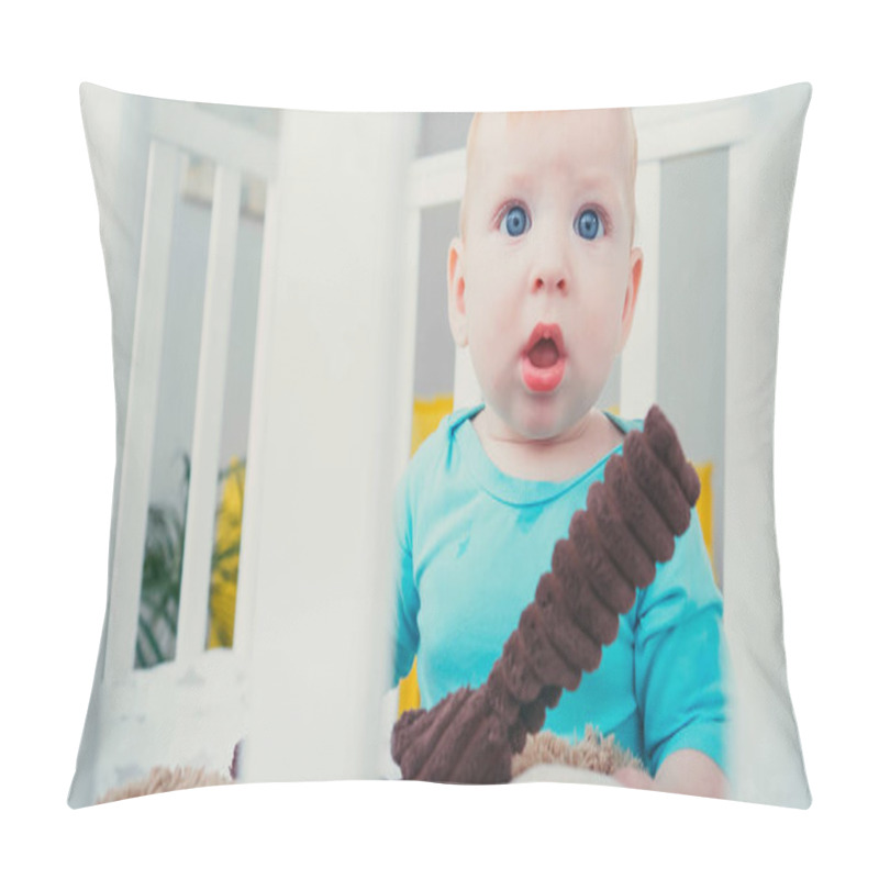 Personality  Surprised Infant Boy Sitting In Blurred Baby Crib With Soft Toy Pillow Covers