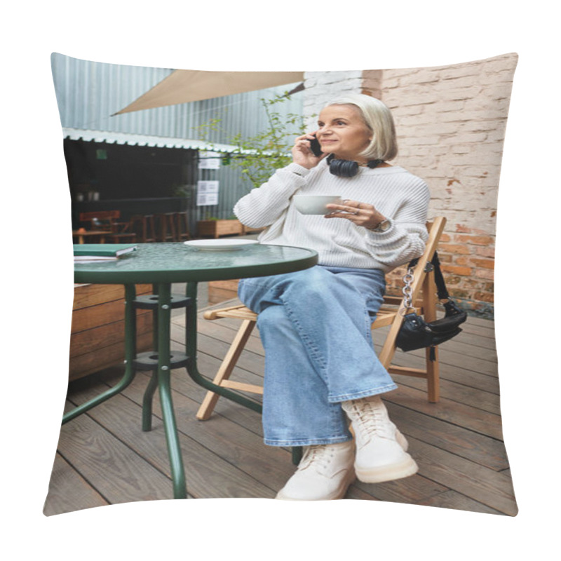 Personality  A Beautiful Mature Woman Sips Coffee And Chats On Her Phone While Seated Outdoors. Pillow Covers