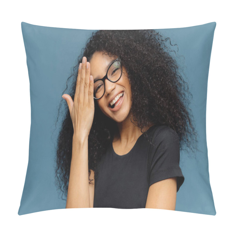 Personality  Happy Afro American Woman Touches Forehead, Tilts Head, Smiles Happily At Camera, Has Fun Indoor, Wears Optical Spectacles And Casual Black T Shirt, Isolated Over Blue Background. Emotions Concept Pillow Covers