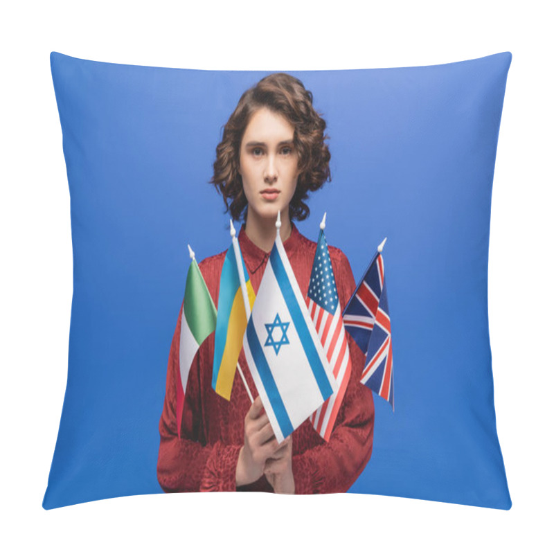 Personality  Young And Confident Woman Looking At Camera While Holding International Flags Isolated On Blue Pillow Covers