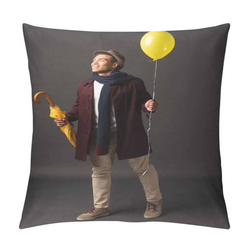 Personality  Smiling Mixed Race Man In Scarf And Hat Holding Yellow Balloon And Umbrella And Looking Away On Black Background Pillow Covers