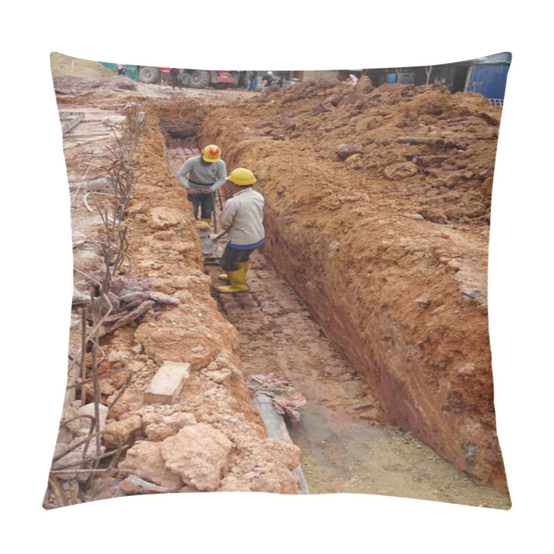 Personality  SEREMBAN, MALAYSIA -MARCH 03, 2020: Construction workers are using the baby compactor to level and compact the soil at the construction site. pillow covers