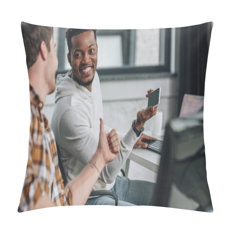 Personality  Selective Focus Of Smiling African American Programmer Holding Smartphone While Sitting Near Colleague Showing Thumb Up Pillow Covers