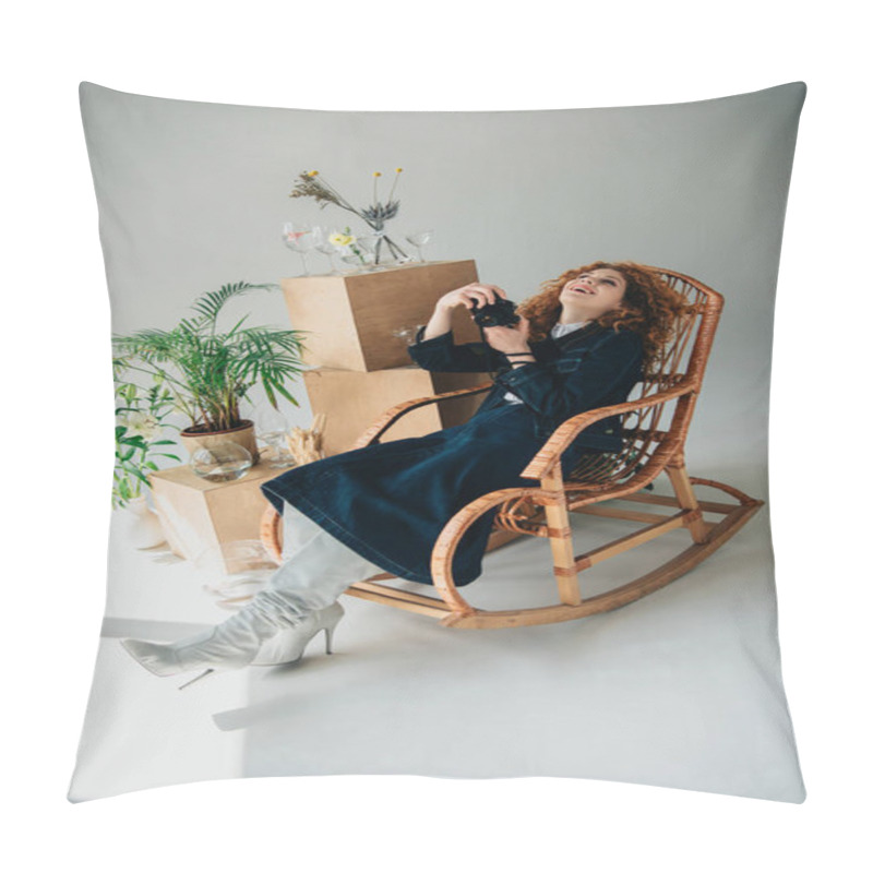 Personality  Stylish Laughing Girl In Wicker Chair With Film Camera Near Wooden Boxes, Glasses And Plants On Grey Pillow Covers