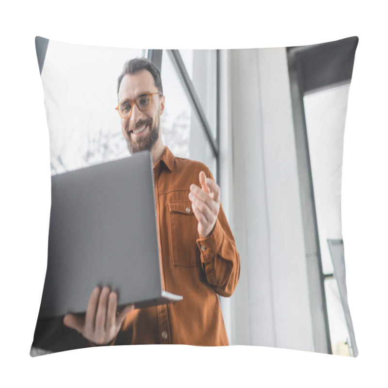 Personality  Low Angle View Of Pleased Bearded Entrepreneur In Fashionable Eyeglasses And Shirt Gesturing During Video Conference On Laptop Near Window In Modern Office, Corporate Lifestyle  Pillow Covers