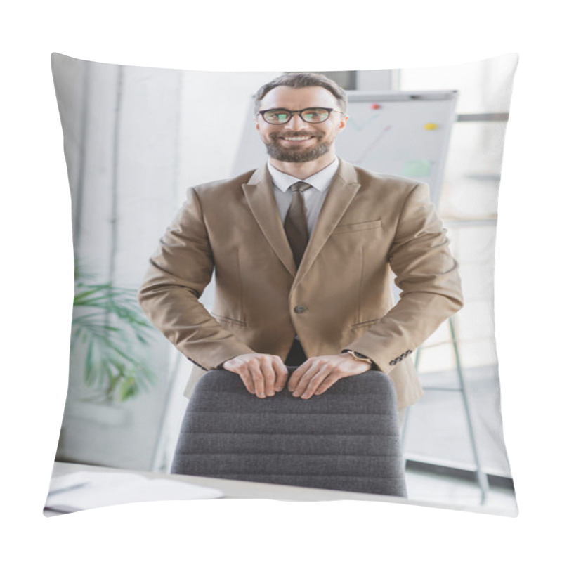 Personality  Joyful Good-looking Businessman In Beige Blazer, Tie And Eyeglasses Standing Near Office Chair And Smiling At Camera In Front Of Flip Chart On Blurred Background Pillow Covers