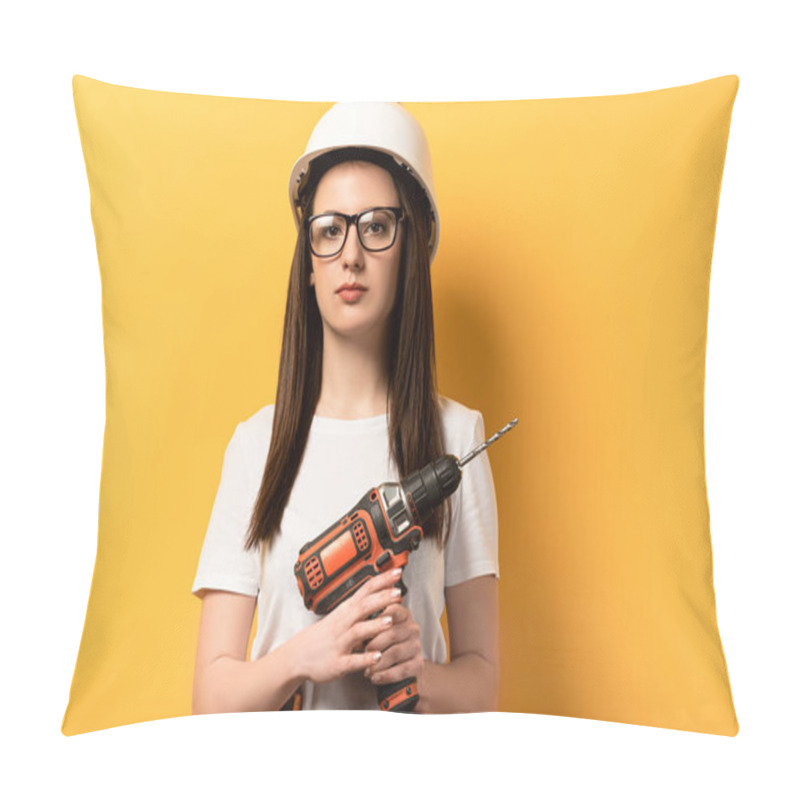 Personality  Serious Handywoman Holding Drill And Looking At Camera On Yellow Background  Pillow Covers